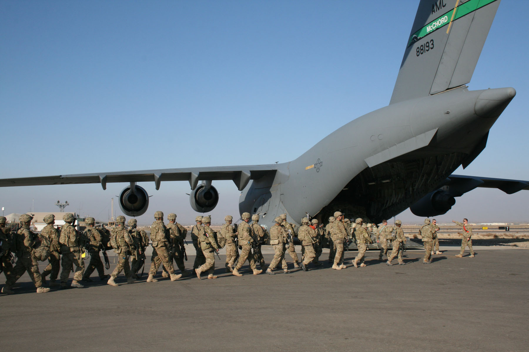Military men boarding a cargo plane for deployment